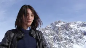femme souriante devant montagne enneigée, entrepreneuriat féminin kazakhstan