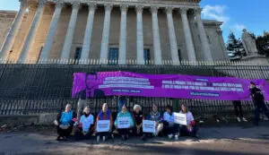 manifestants devant l'assemblée nationale avec bannière violette pour la solidarité