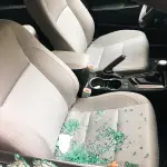 Car interior with shattered glass from a broken window.